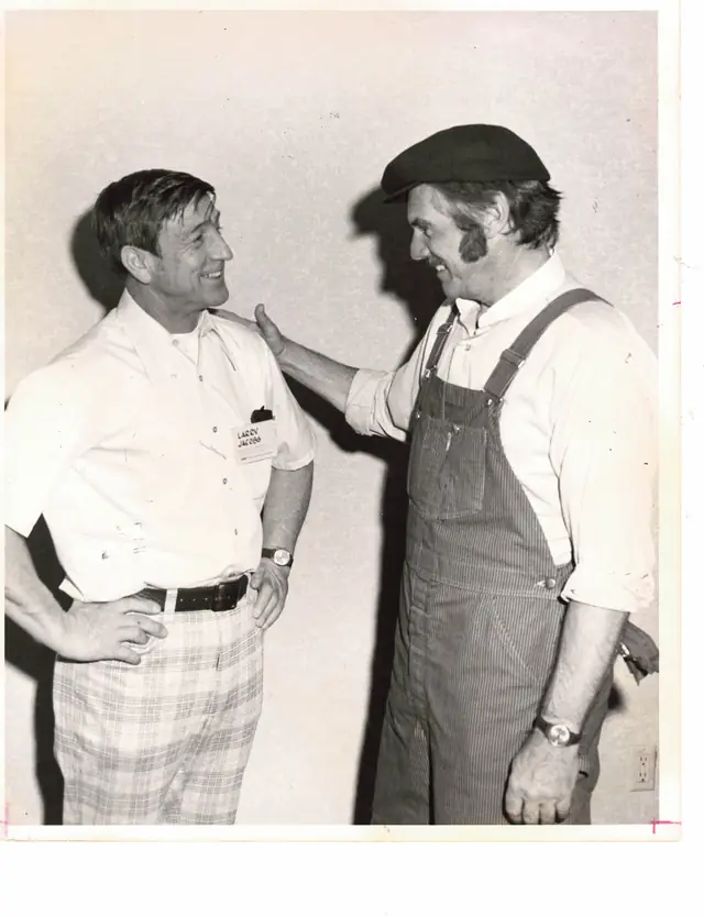 Archival black-and-white photo of founder Larry Jacobs, left, wearing his name badge