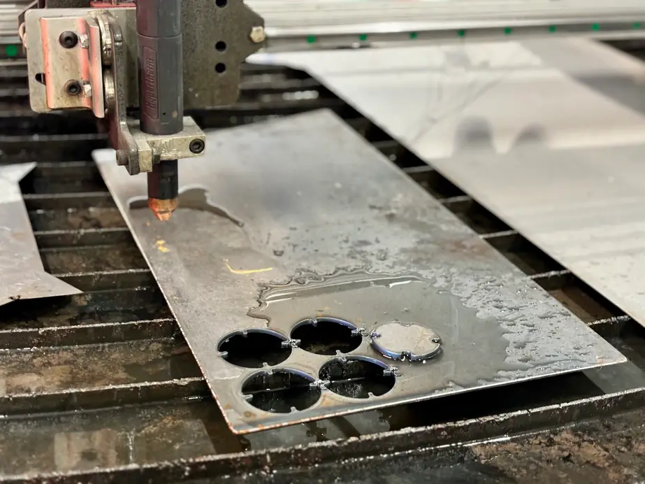 A plasma cutter mid-cut on sheet steel in the Jacobs and Rhodes shop